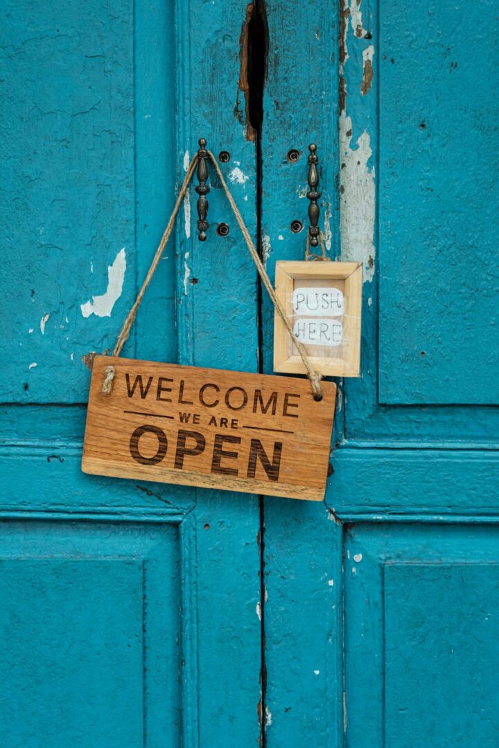 A wooden sign hanging on the front of a door.