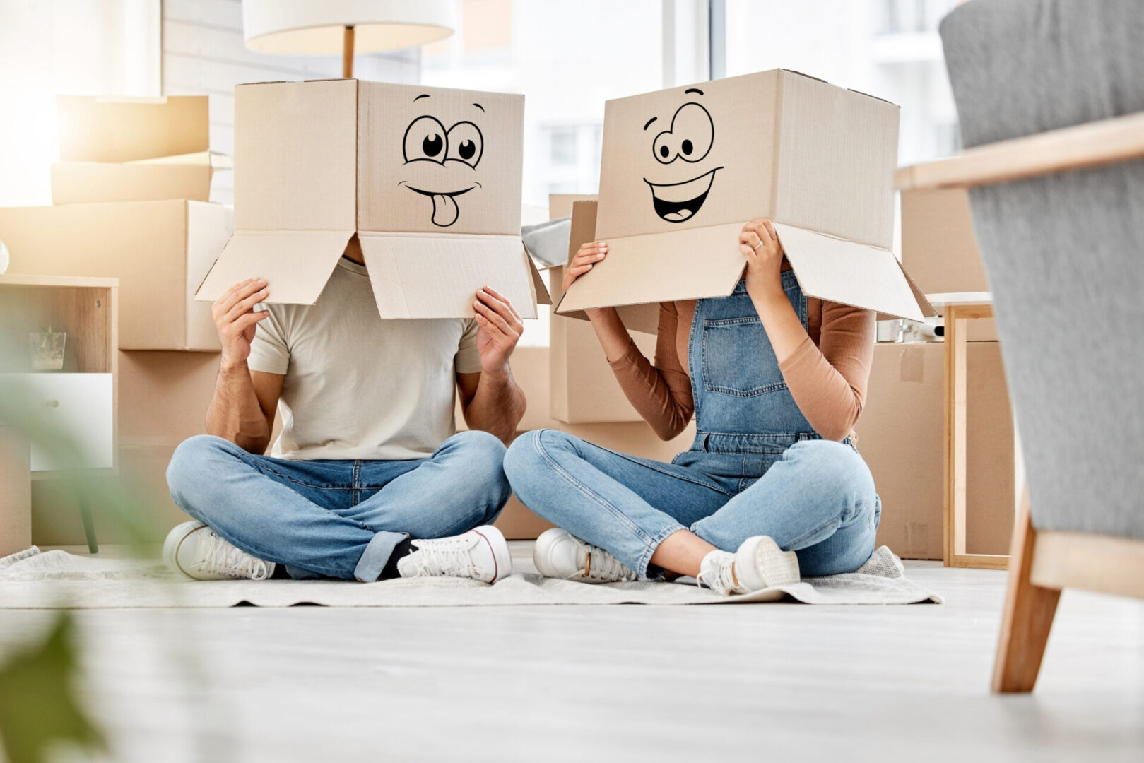 Two people sitting on the floor with boxes on their heads