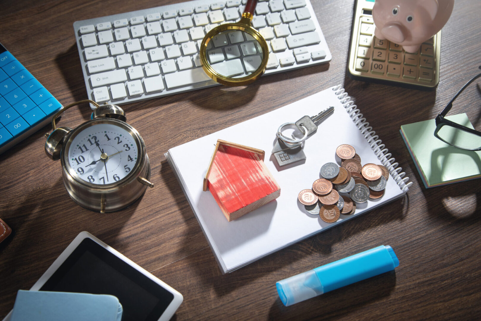 A desk with keys, coins and a clock.