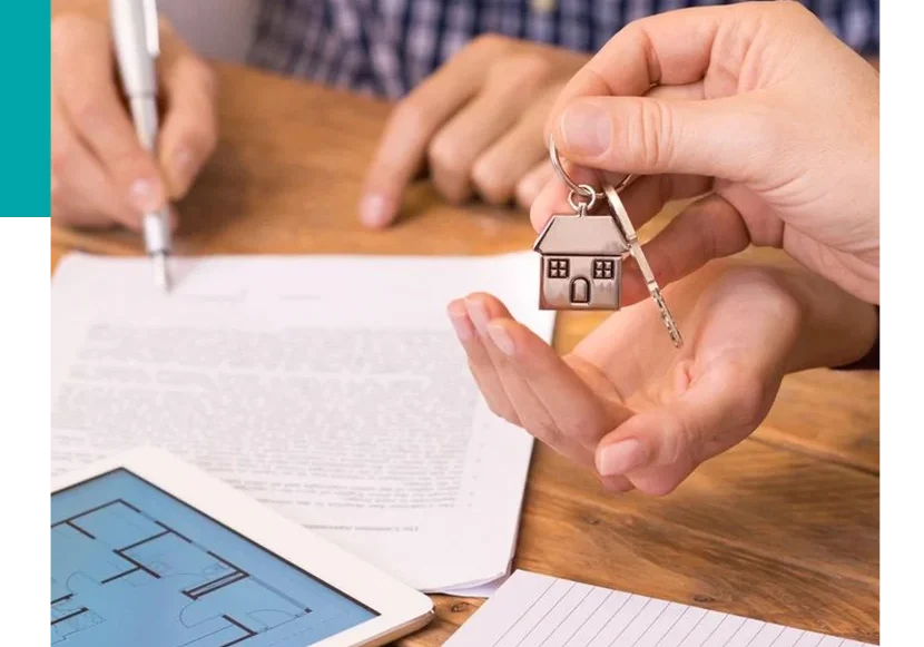 Two people are holding keys to a house.